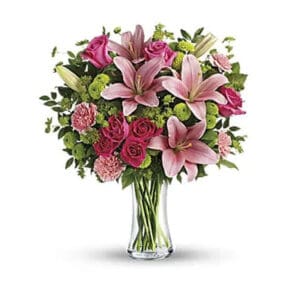 Pink lilies and roses in glass vase.