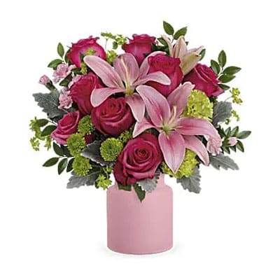 Pink lilies and roses in pink vase.