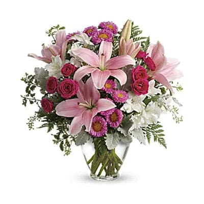 Pink lilies and roses in a vase.